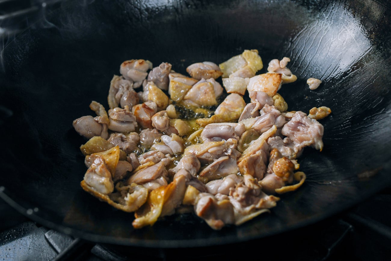 shallow-frying chicken thigh pieces in wok
