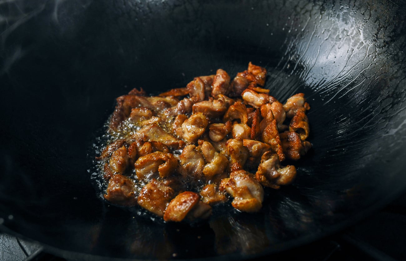 shallow-fried boneless chicken thigh pieces in wok