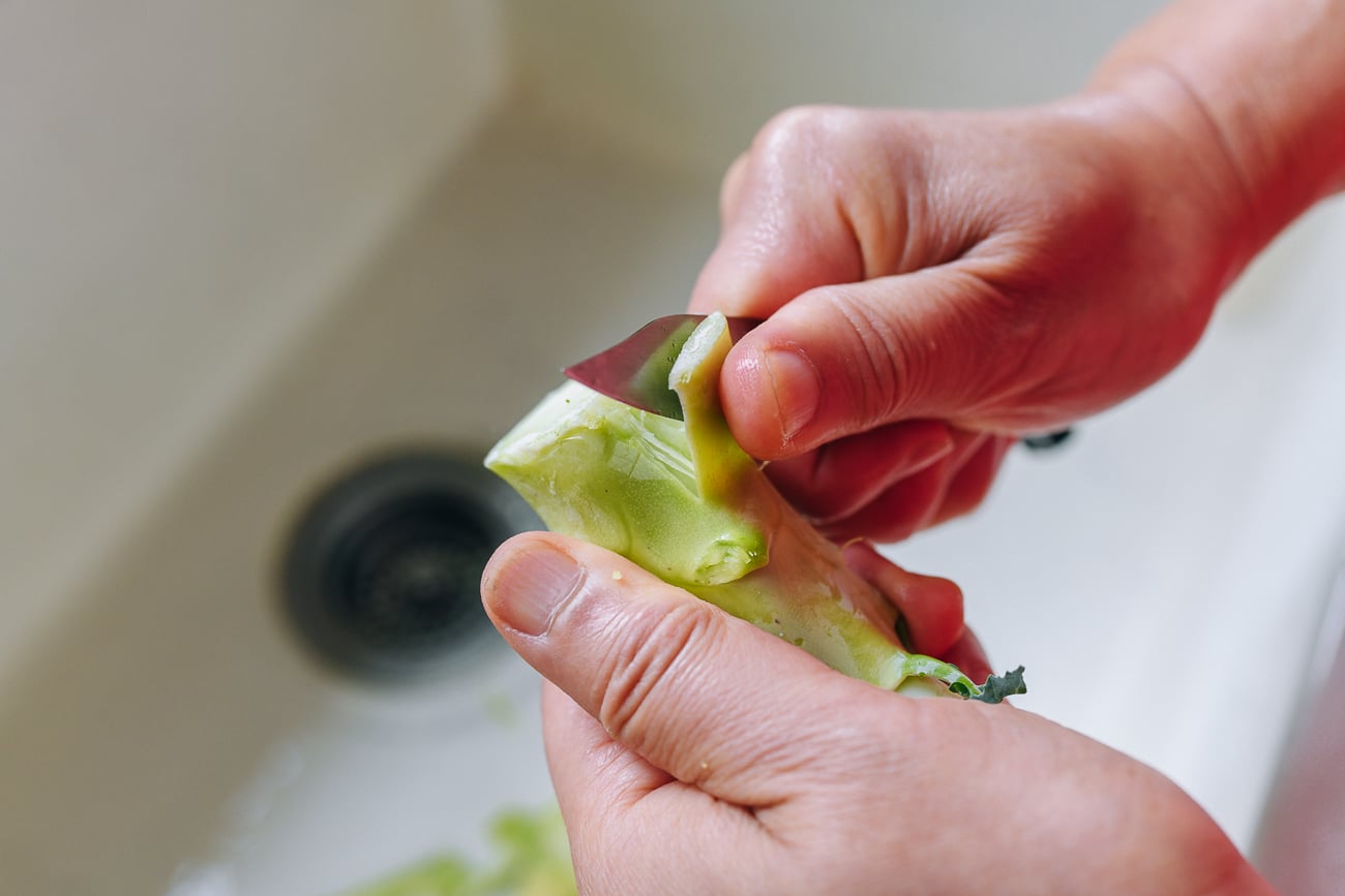 peeling tough outer layer from broccoli stem using paring knife