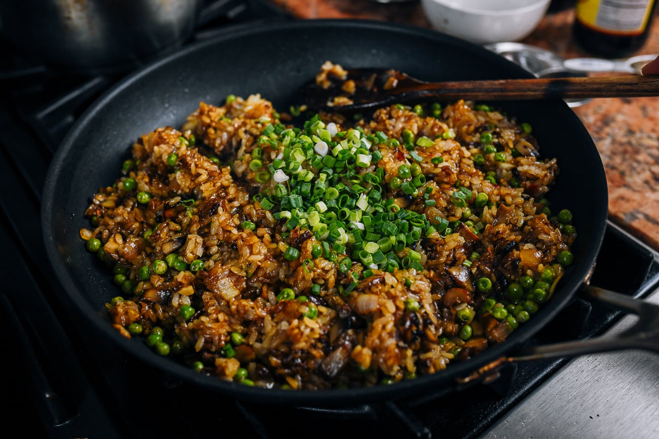 adding scallions to fried sticky rice