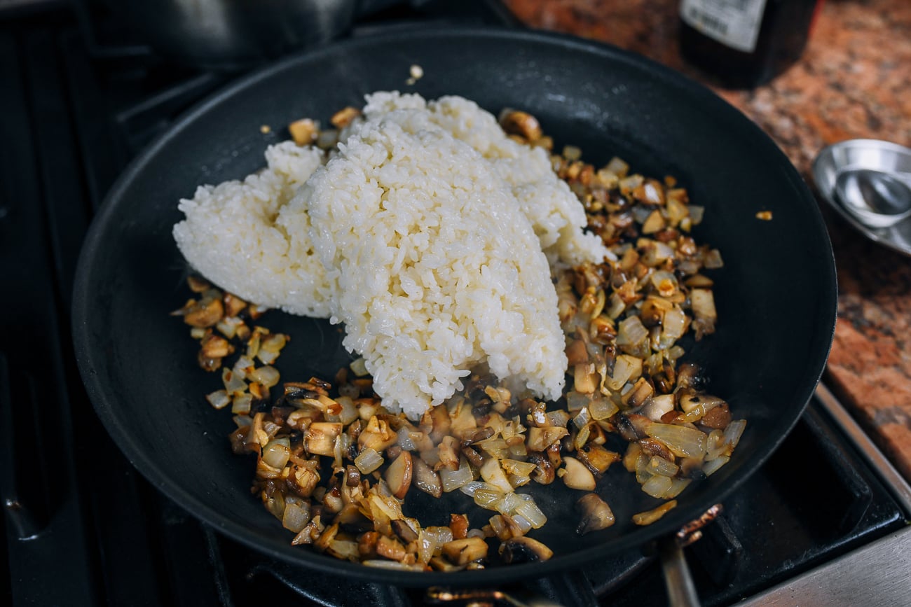 adding sticky rice to pan with mushrooms, onions, and garlic