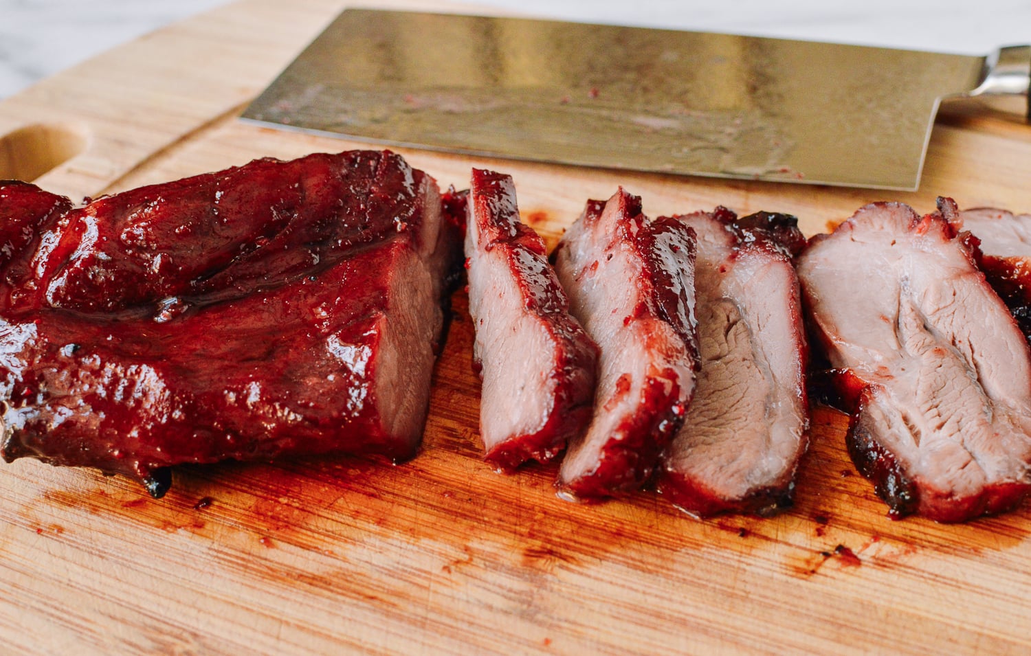 sliced char siu on cutting board