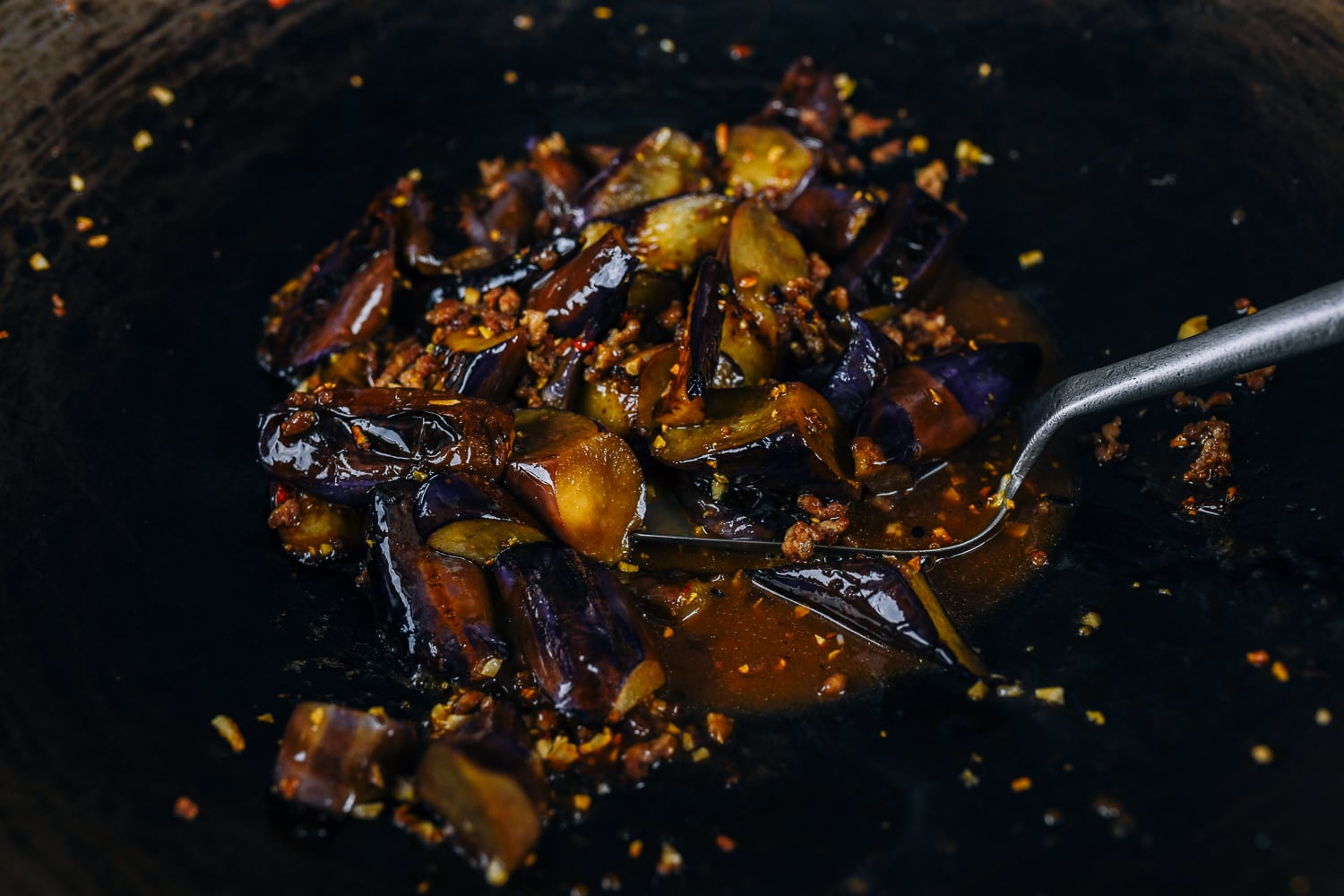 cooking eggplant with garlic sauce in wok