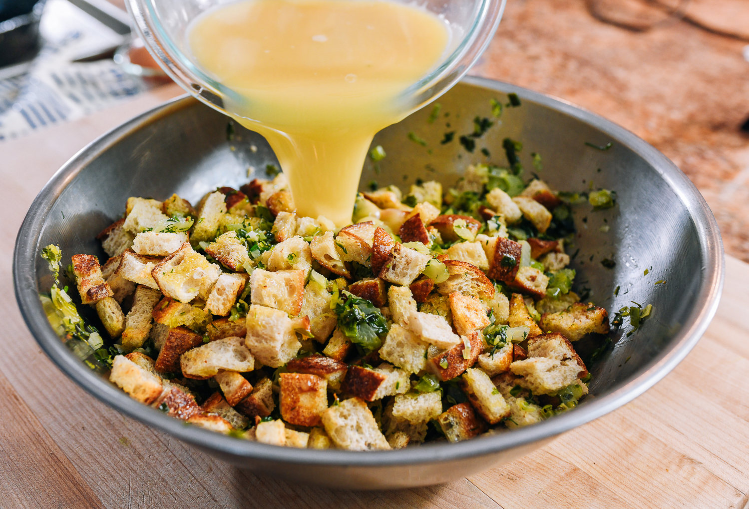 pouring egg and stock mixture into stuffing