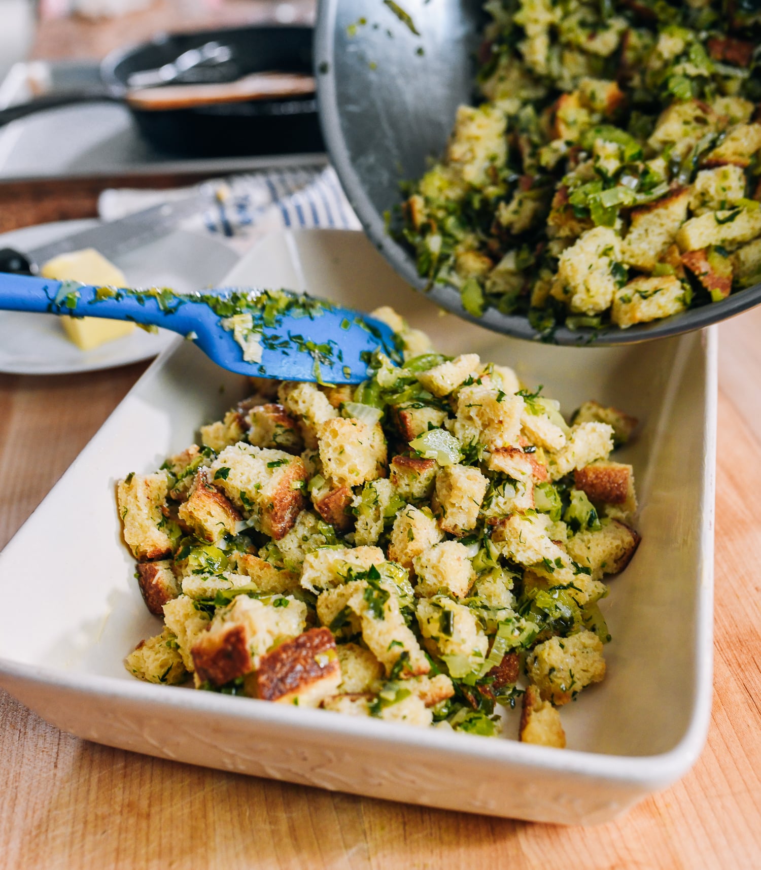transferring stuffing mixture from mixing bowl to baking dish