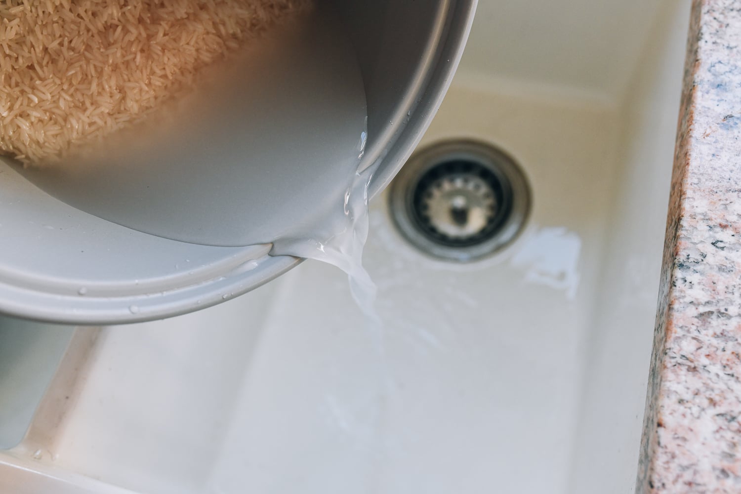 pouring off water after rinsing rice