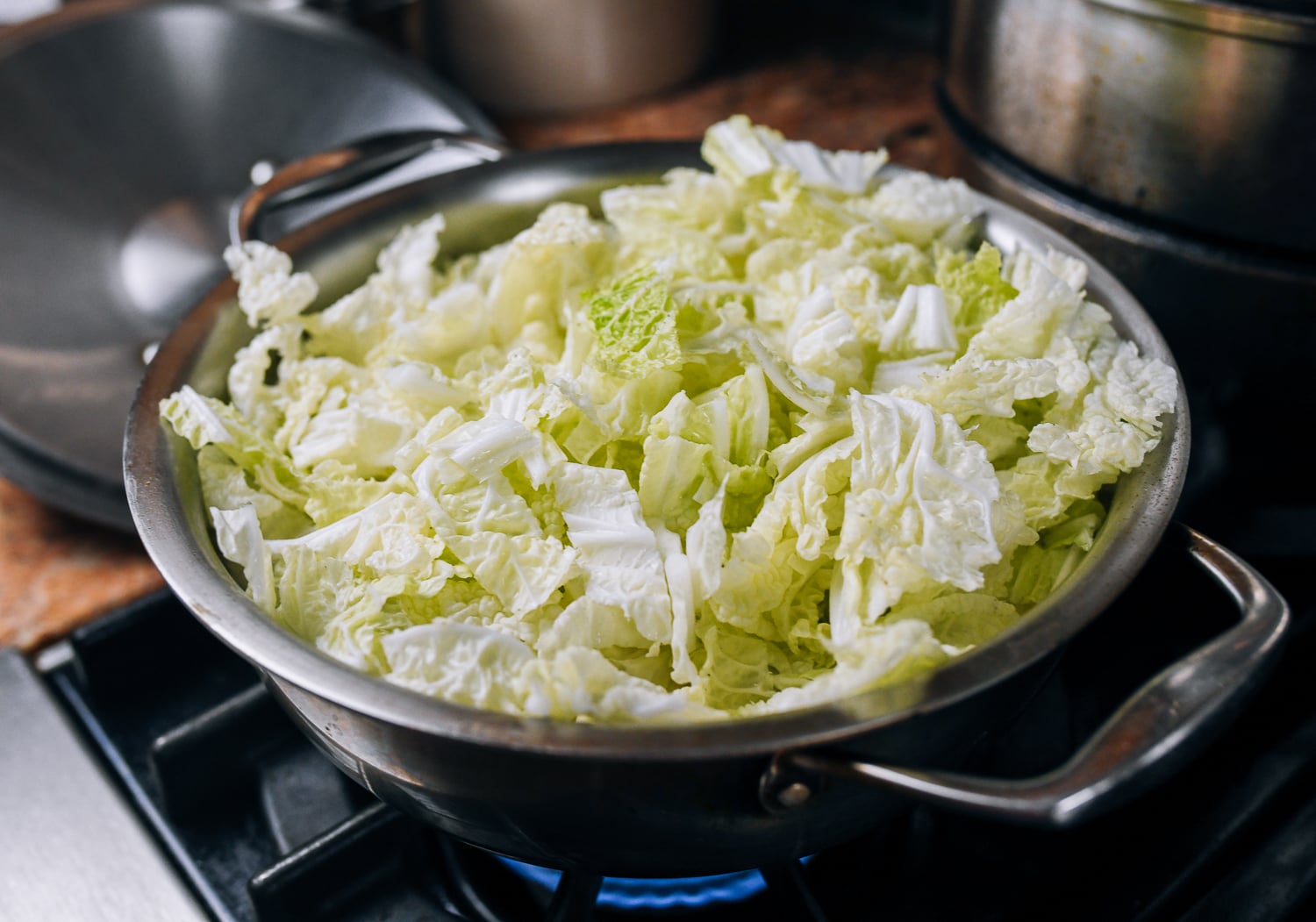 napa cabbage added to soup pot