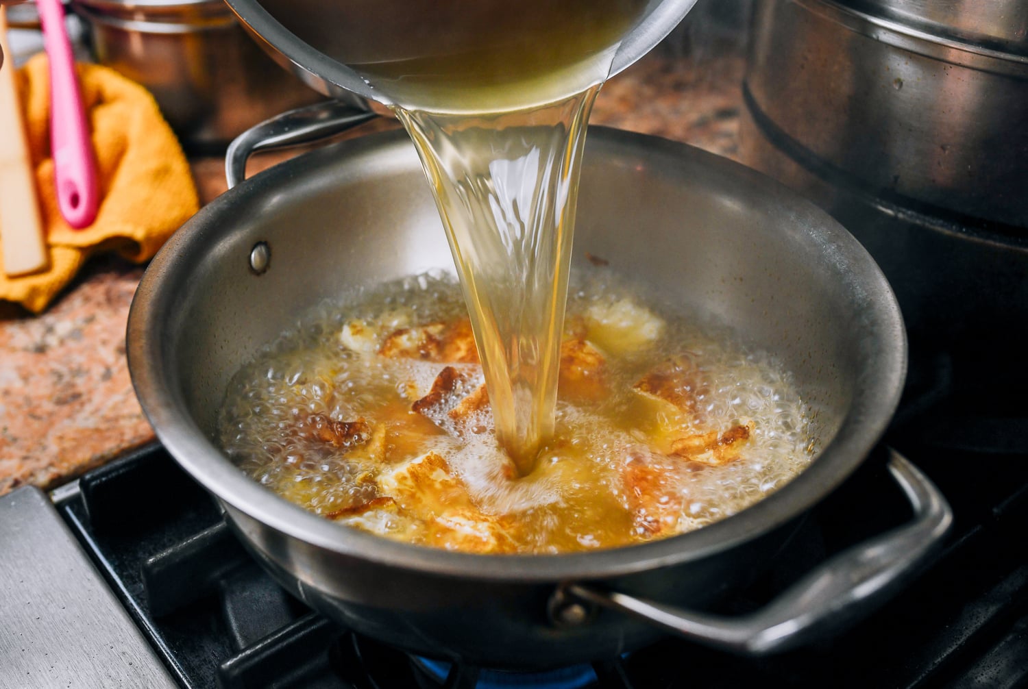 pouring stock into pot with eggs