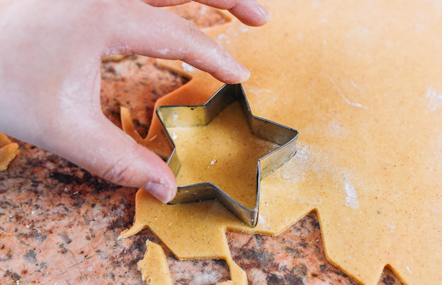 cutting cookies with star shaped cookie cutter