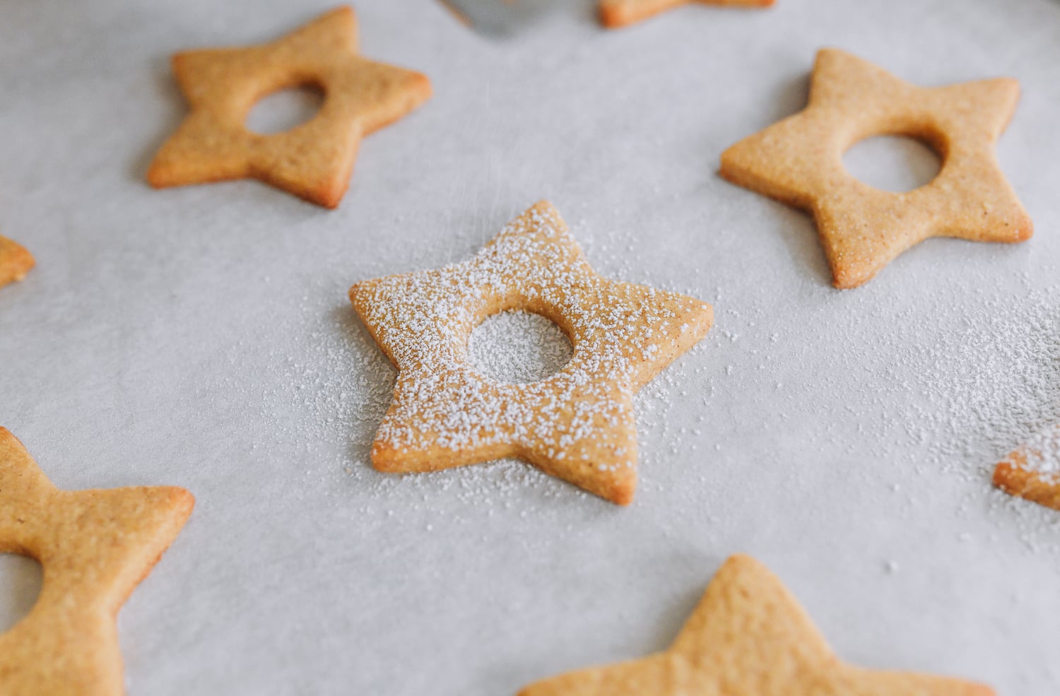 dusting linzer cookie lids with powdered sugar