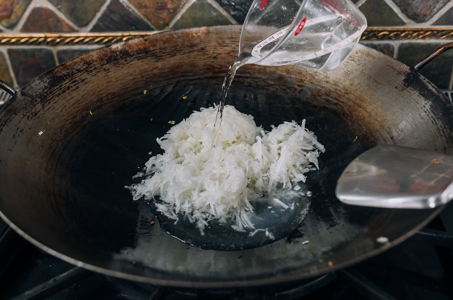 grated radish and water in wok