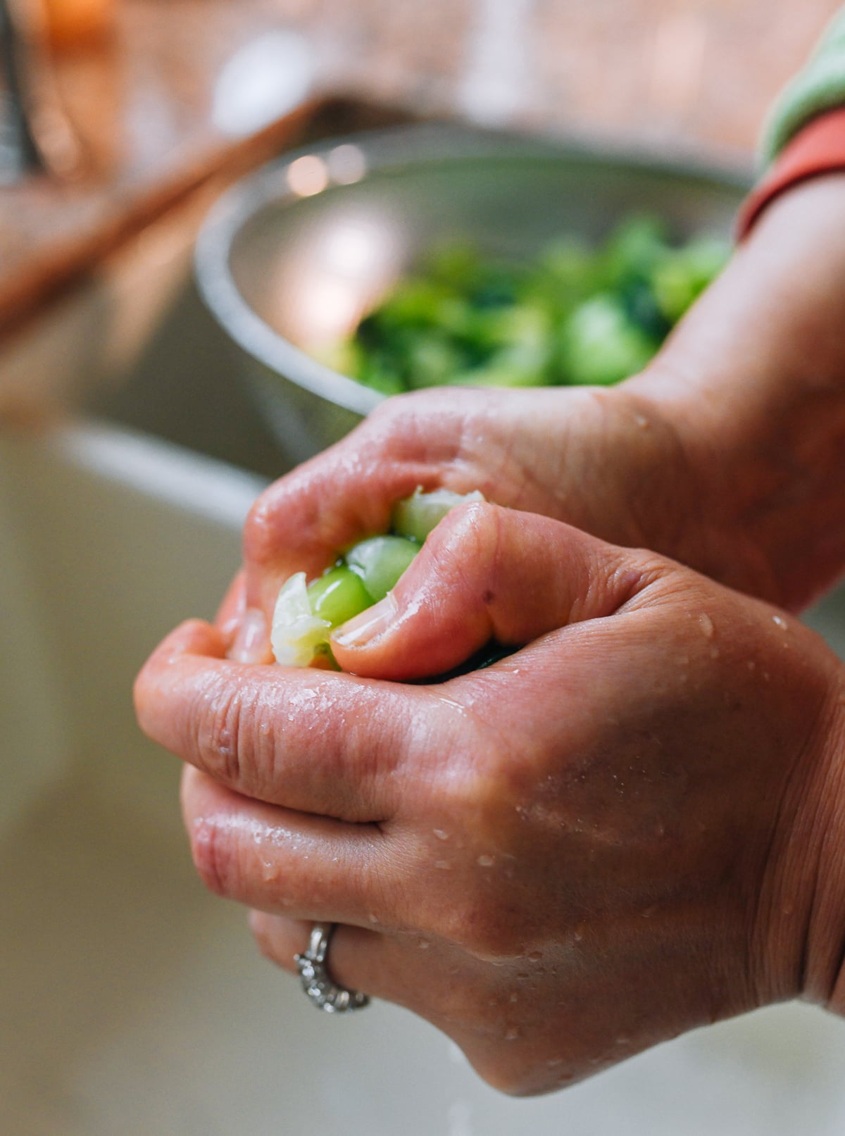 squeezing water out of blanched baby bok choy