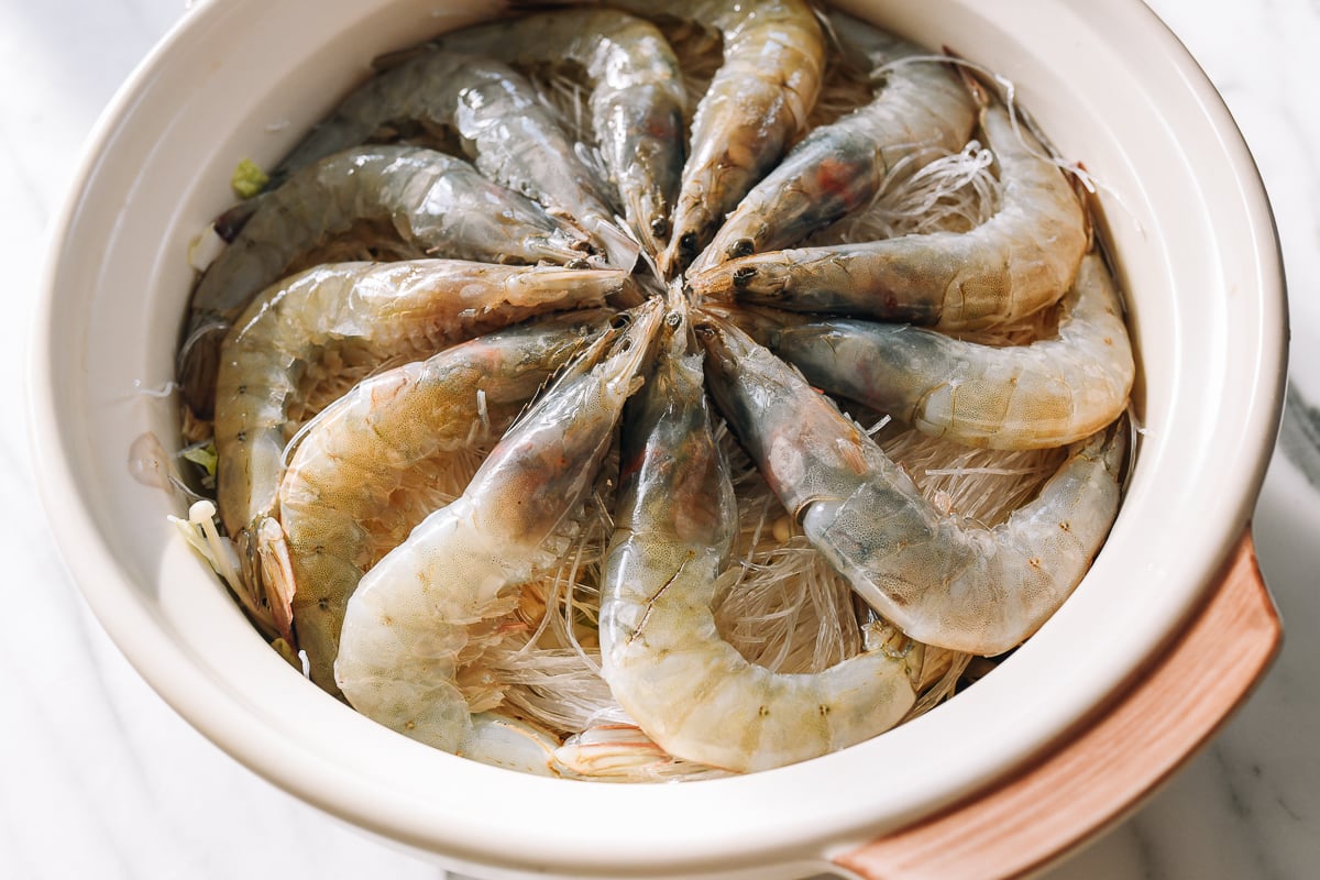 shrimp arranged in a circle in a pot with noodles and vegetables