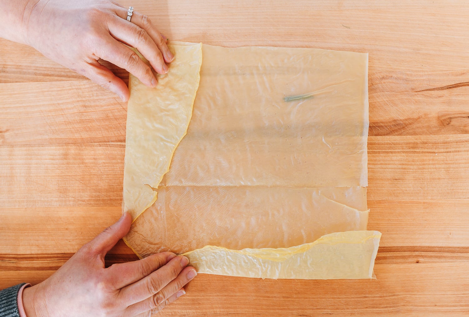 folding in edges of bean curd skin sheet to make a rectangle