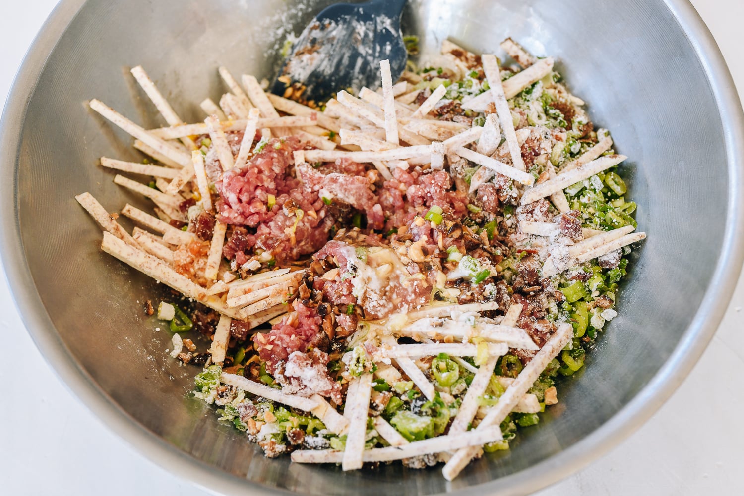 mixing julienned taro with ground meat, mushrooms, scallions, and other ingredients