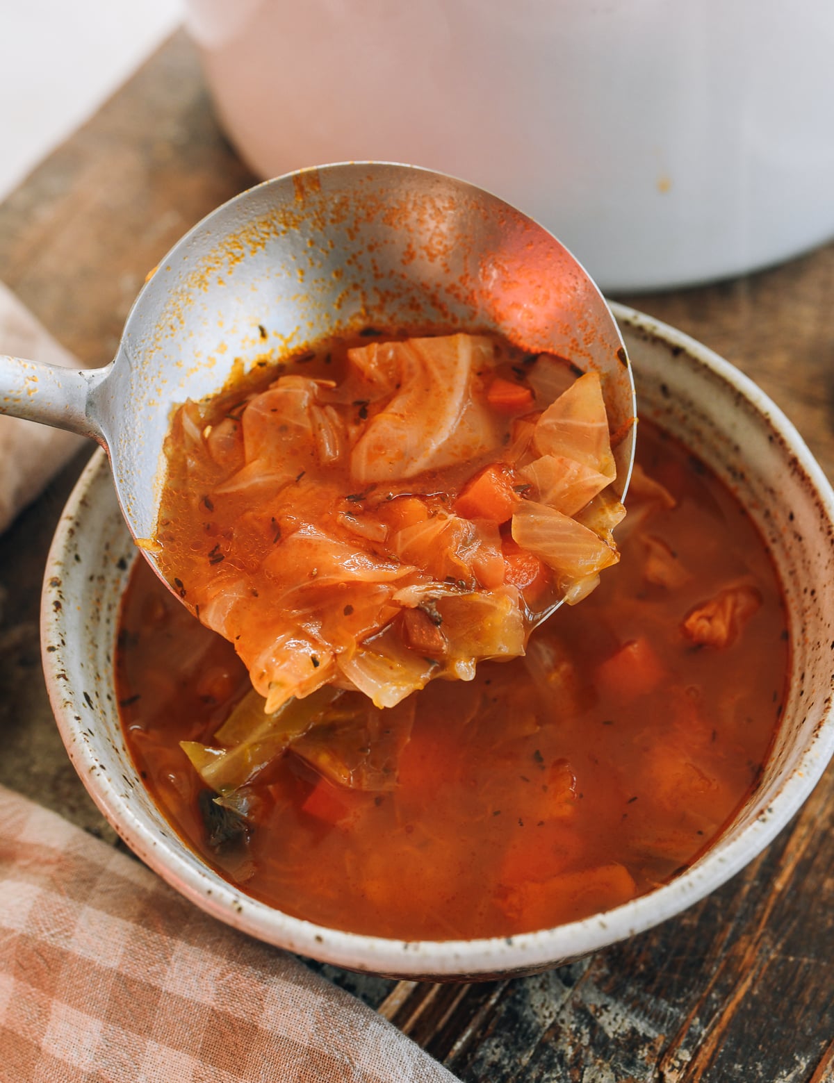 ladling winter vegetable soup in bowl