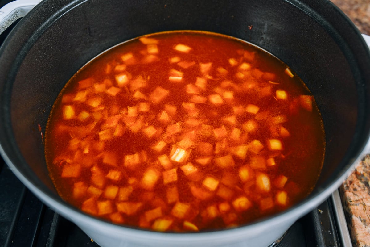 water added to tomato paste and onion in pot