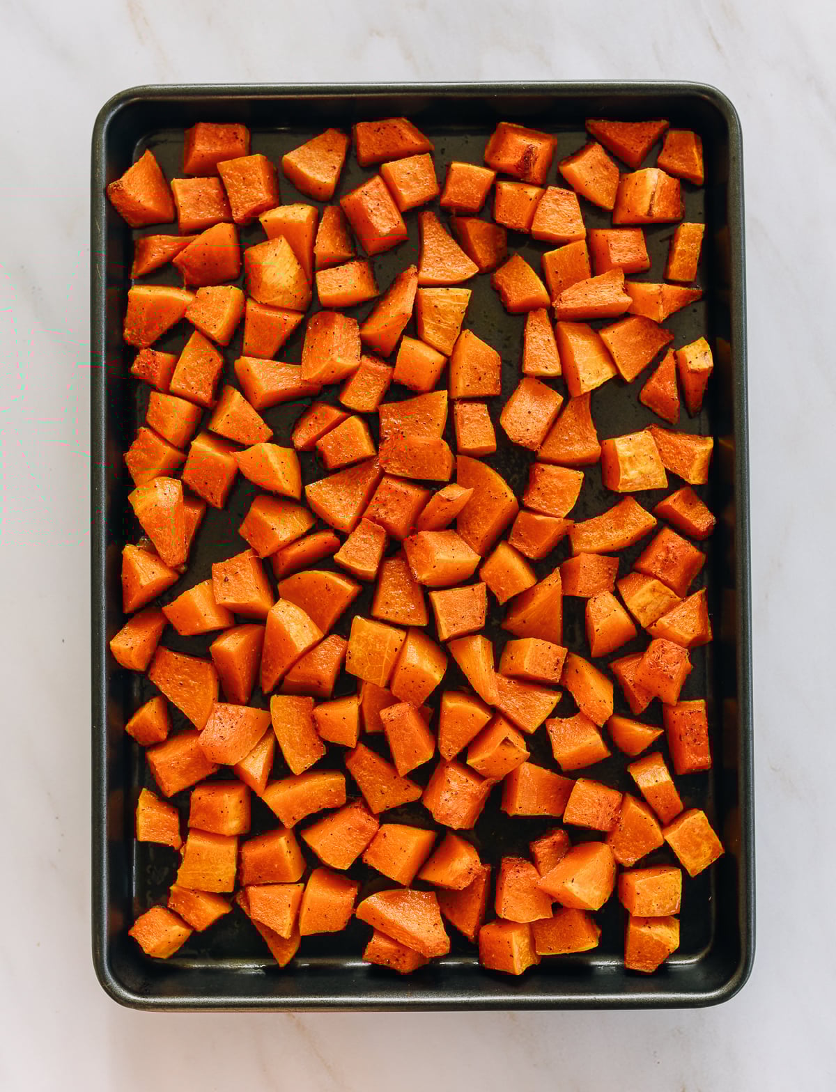 Cubed butternut squash on sheet pan
