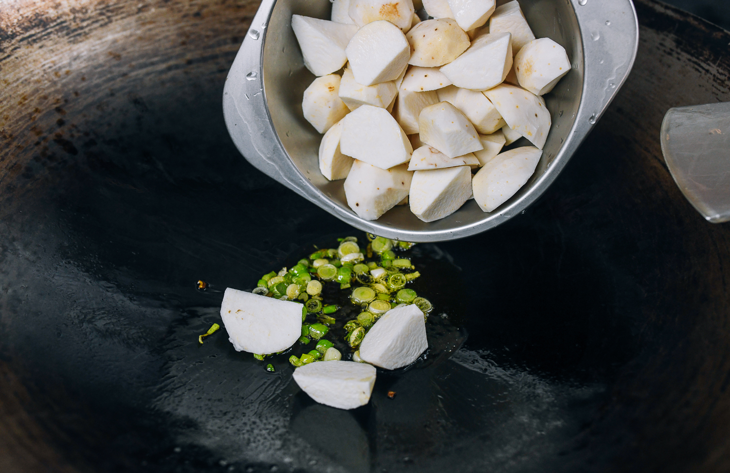 adding taro to scallion whites in wok