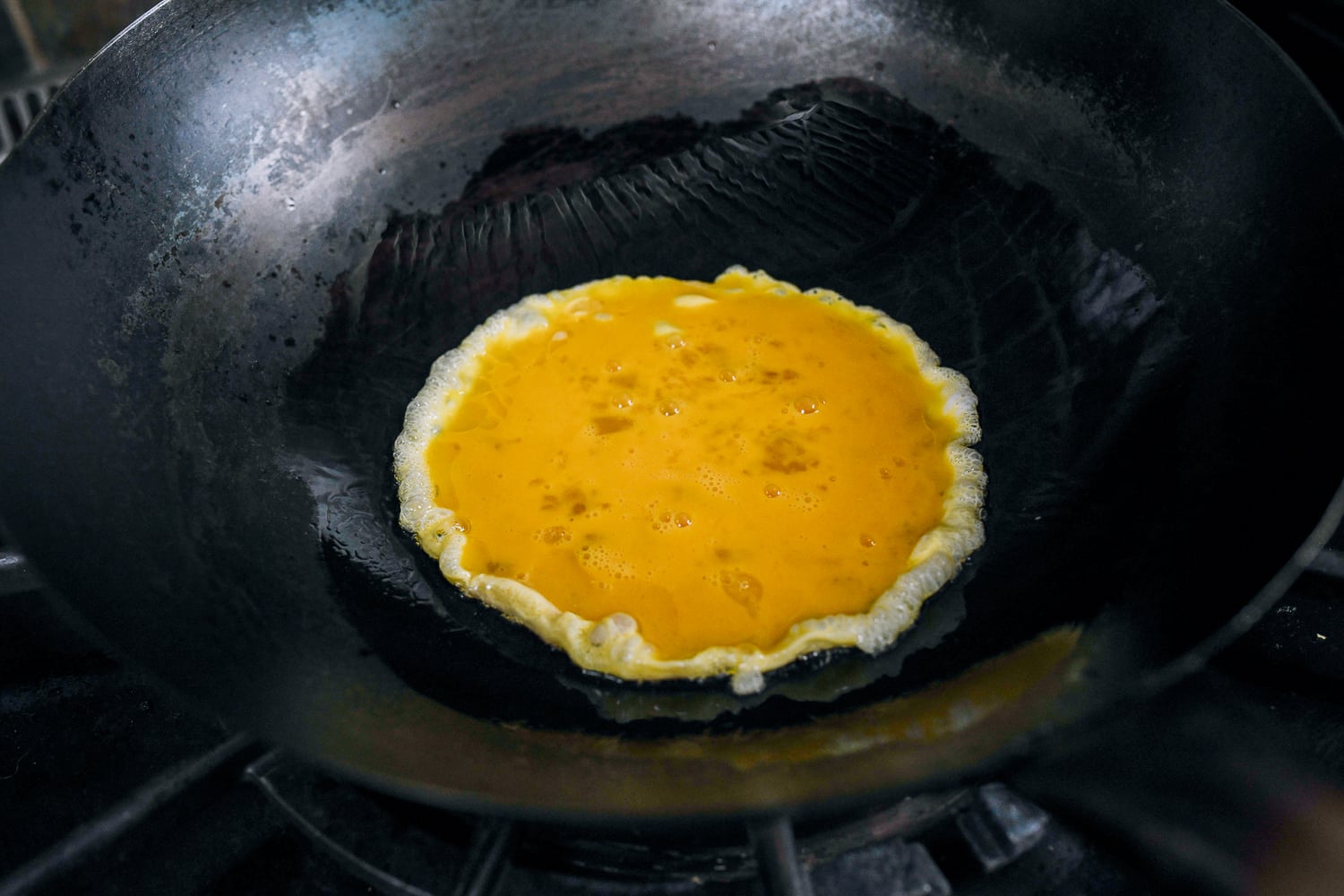 beaten egg added to oil in wok