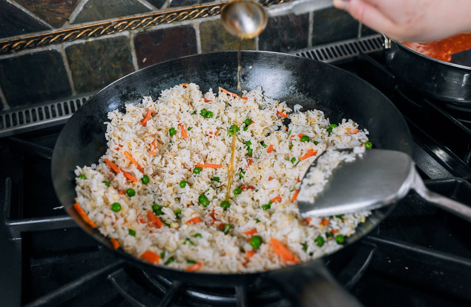 egg fried rice in wok with peas and carrots