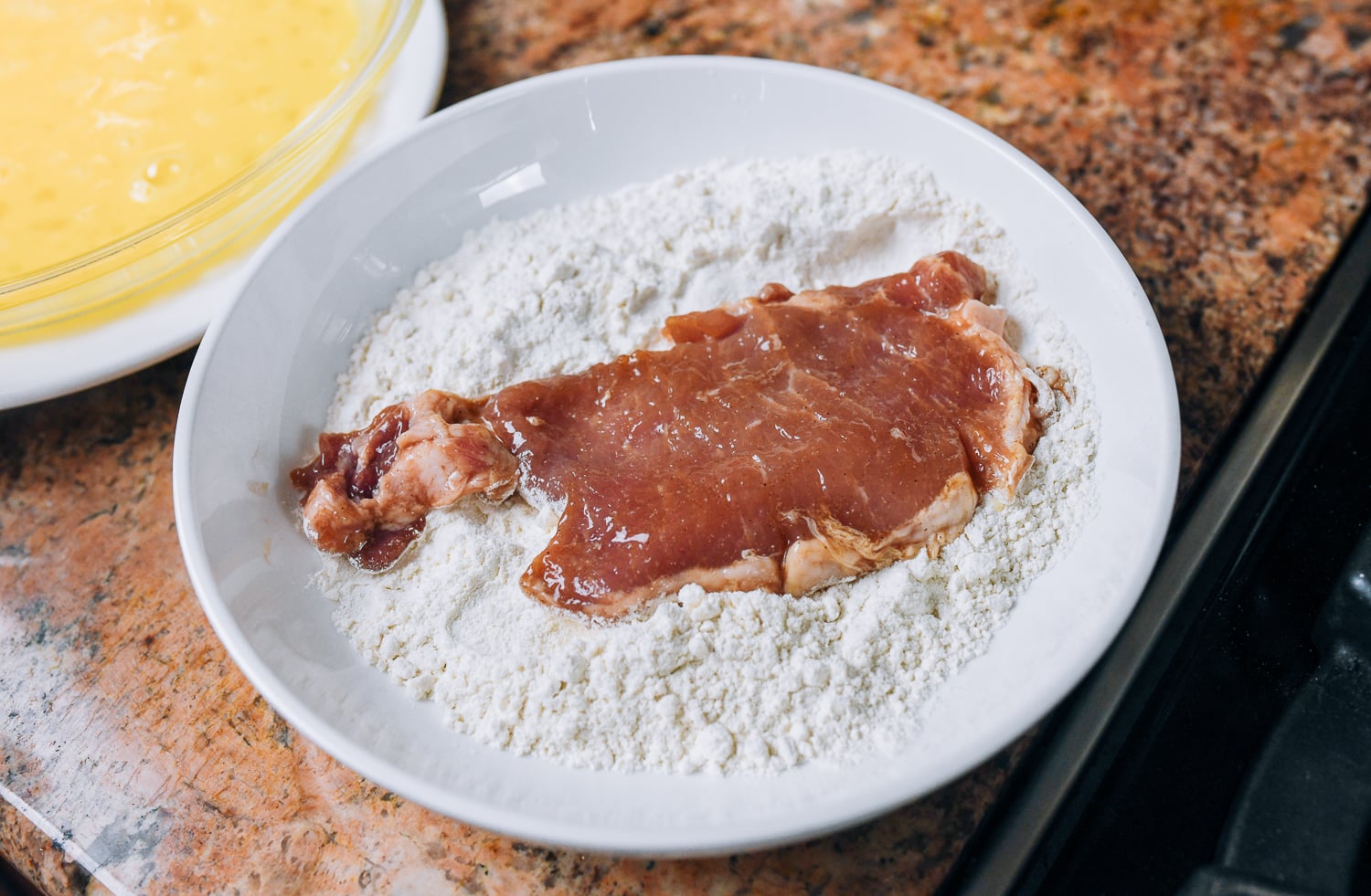 dredging pork chop in flour