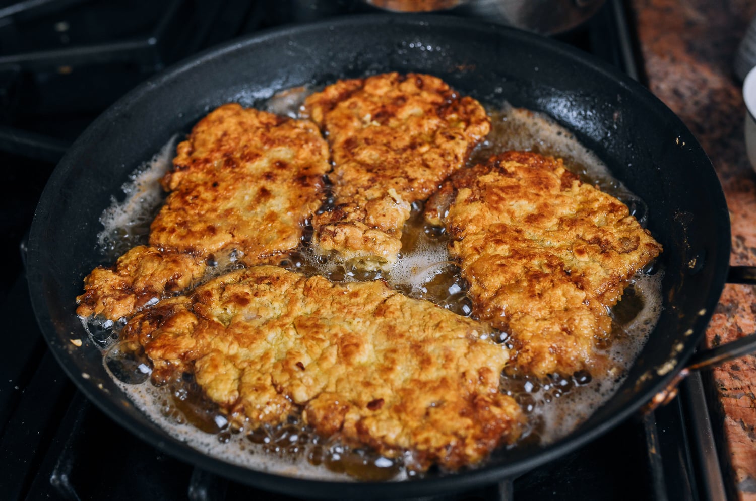 shallow fried pork chops in pan of oil