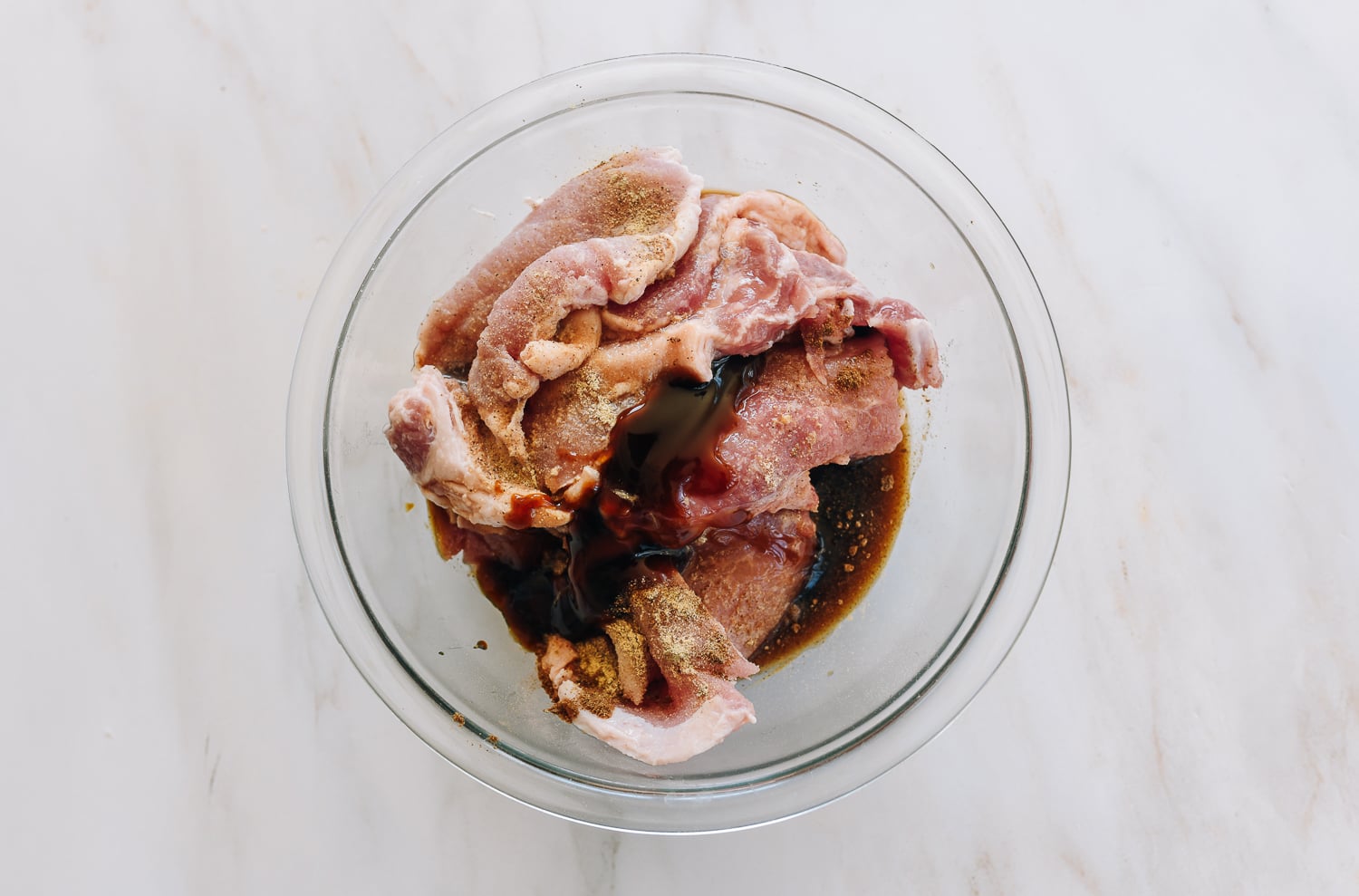 pork chops and marinade ingredients in glass bowl