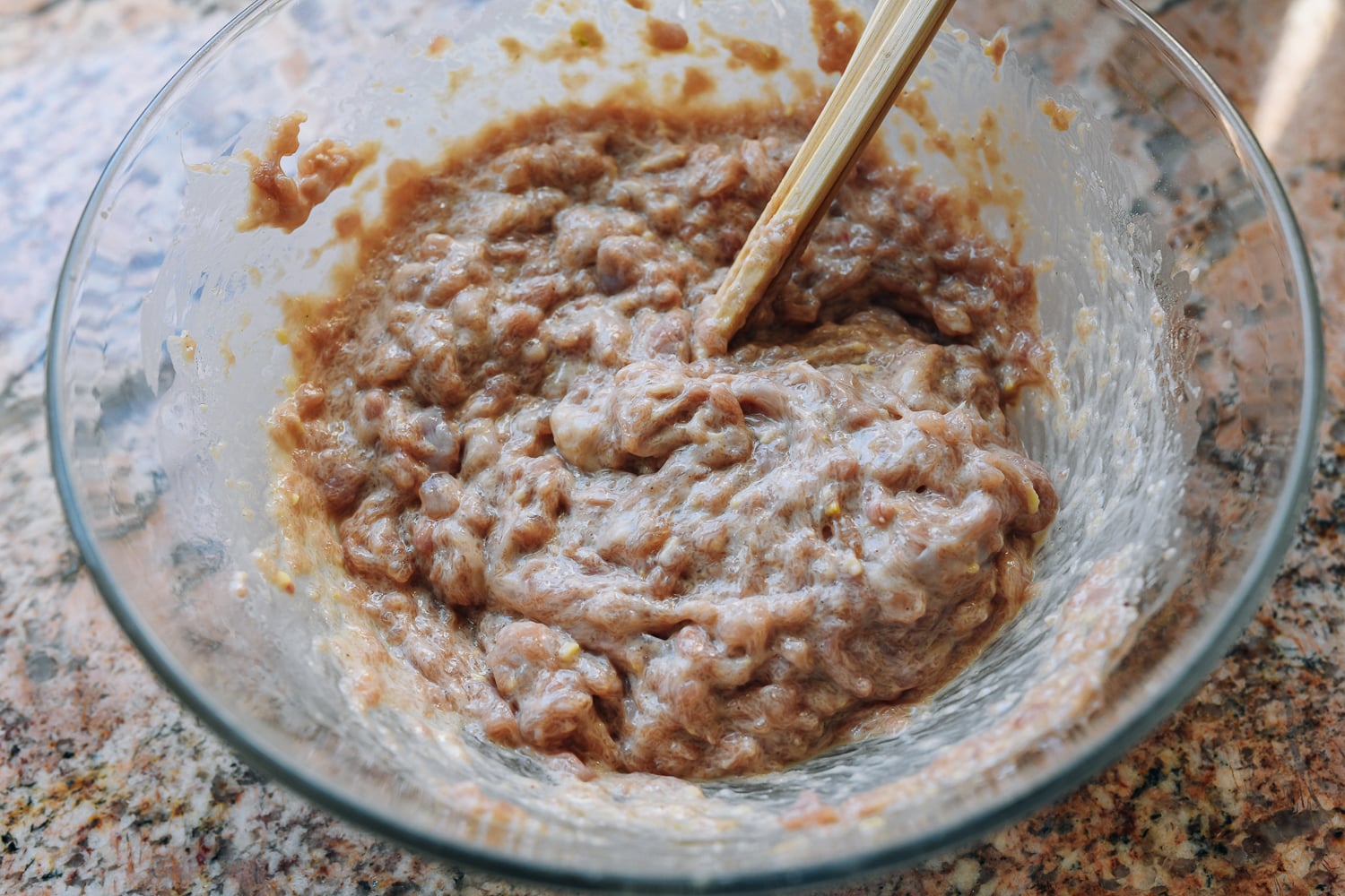 mixing ground chicken with seasonings for dumpling filling