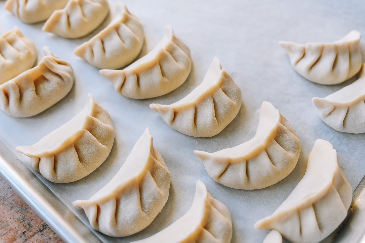 assembled dumplings on parchment-lined baking sheet
