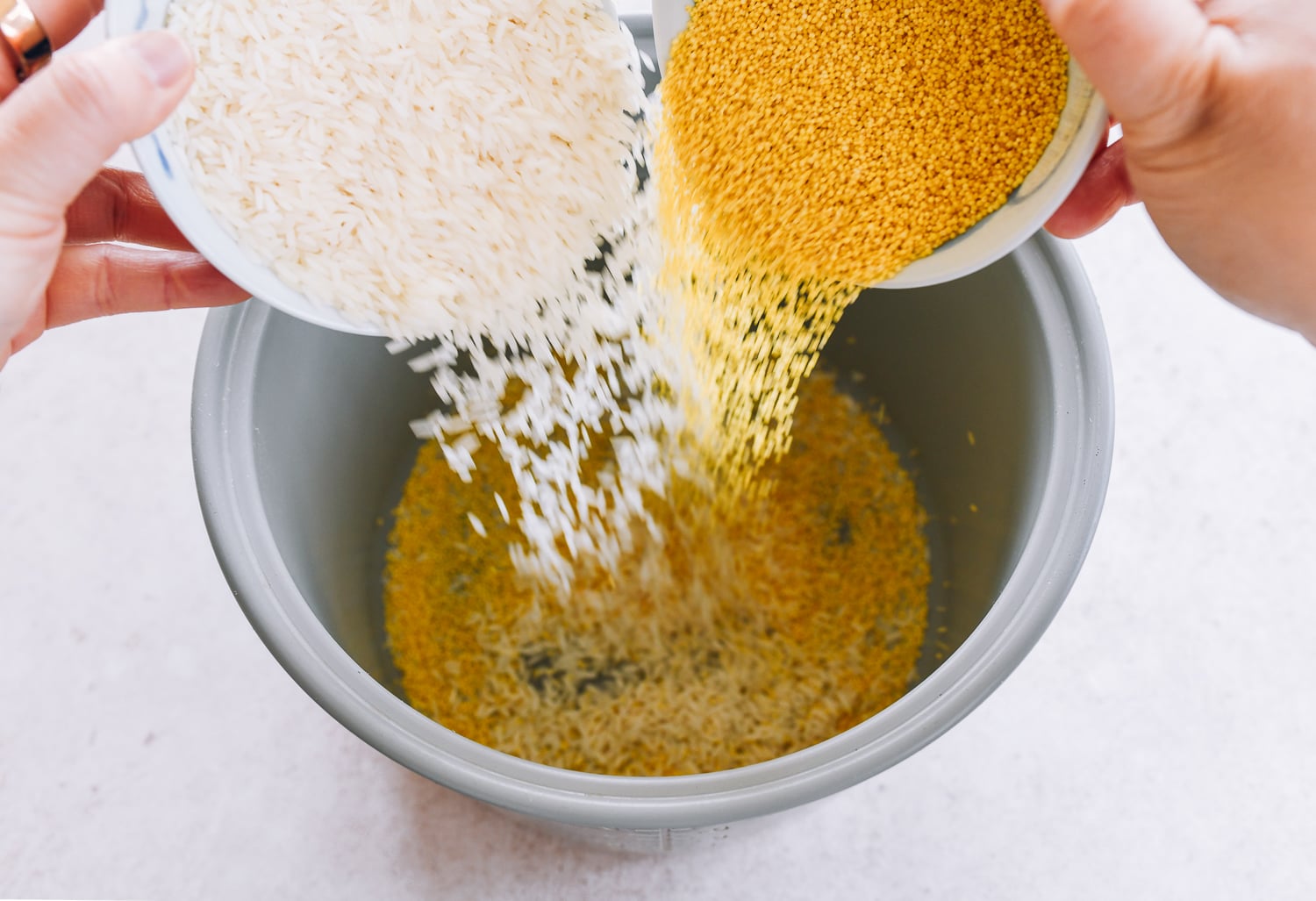 jasmine rice and millet being added to rice cooker