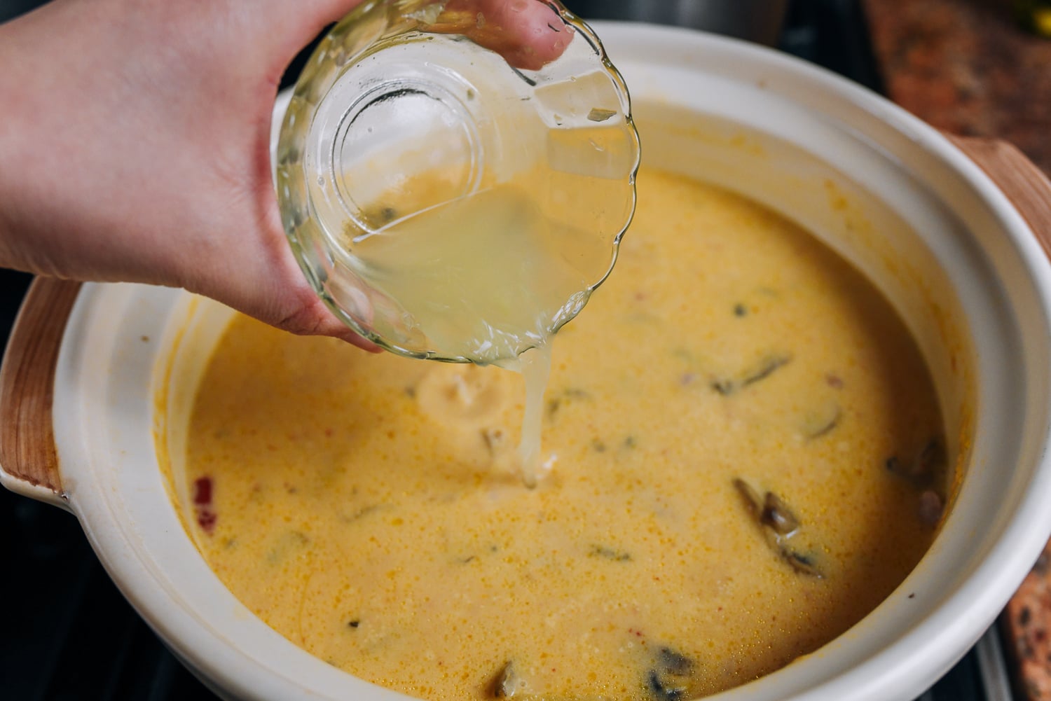 adding lime juice to thai coconut soup