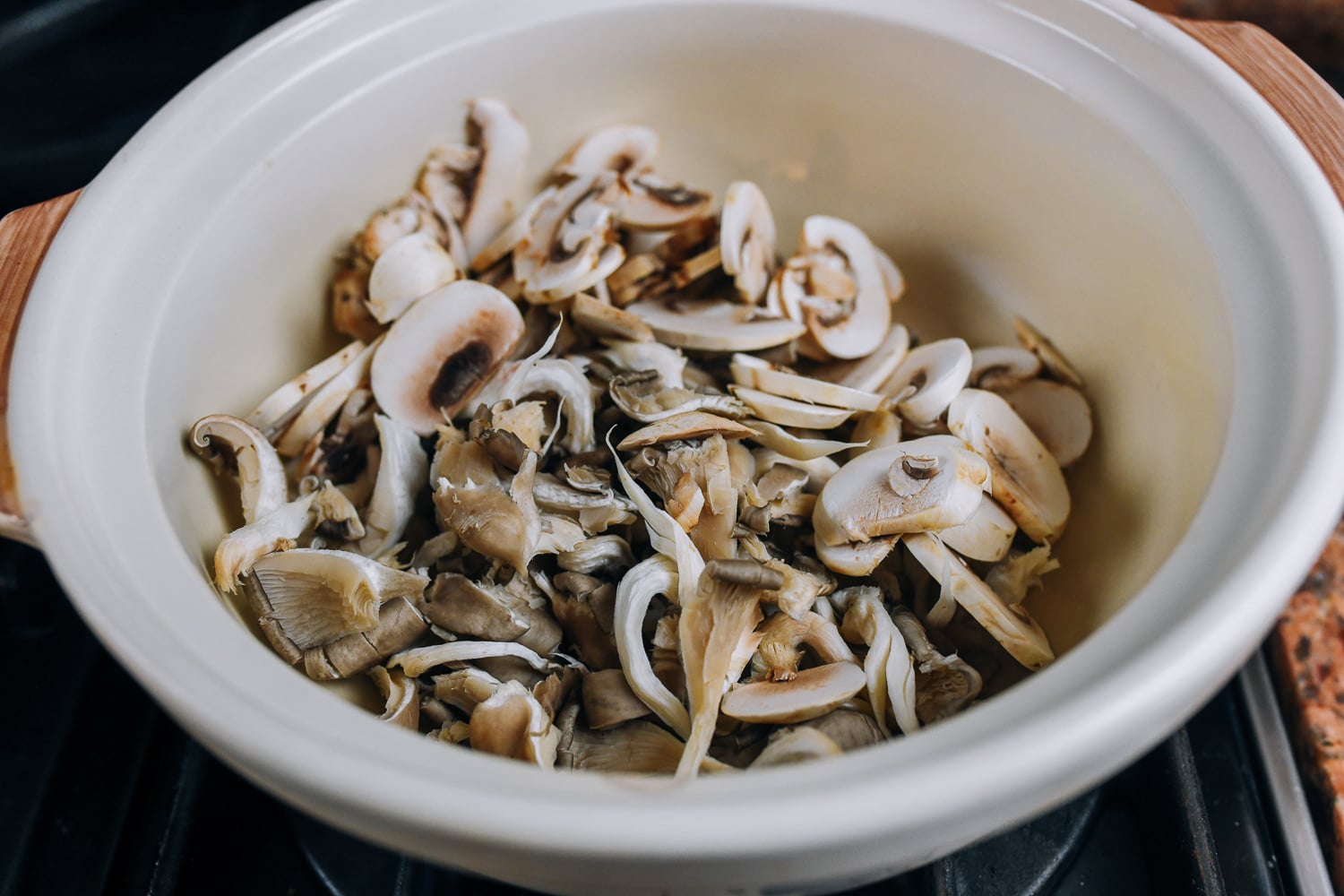 oyster and button mushrooms cooking in clay soup pot