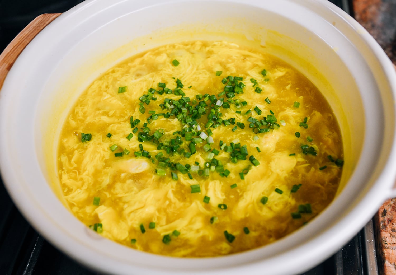 stirring scallions into soup