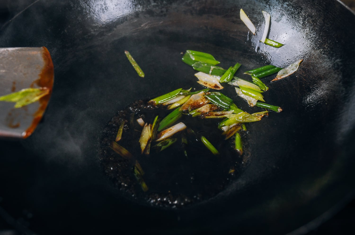 oyster sauce, soy sauce, and scallions in wok