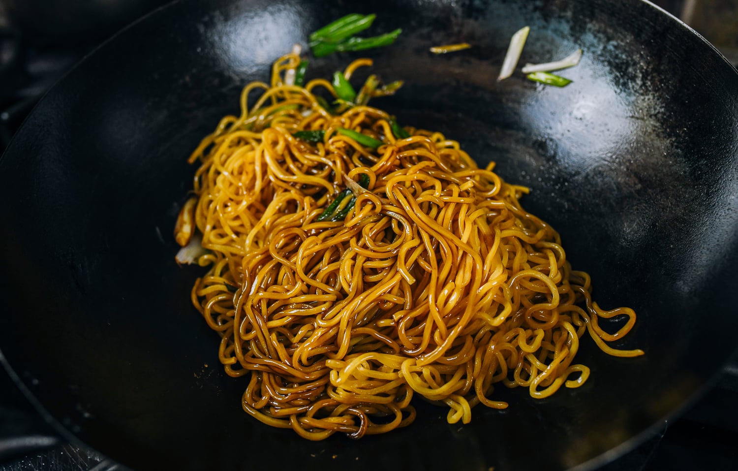 tossing lo mein noodles with sauce