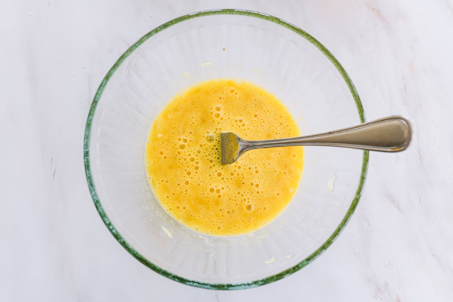 egg and mashed banana beaten together in glass bowl