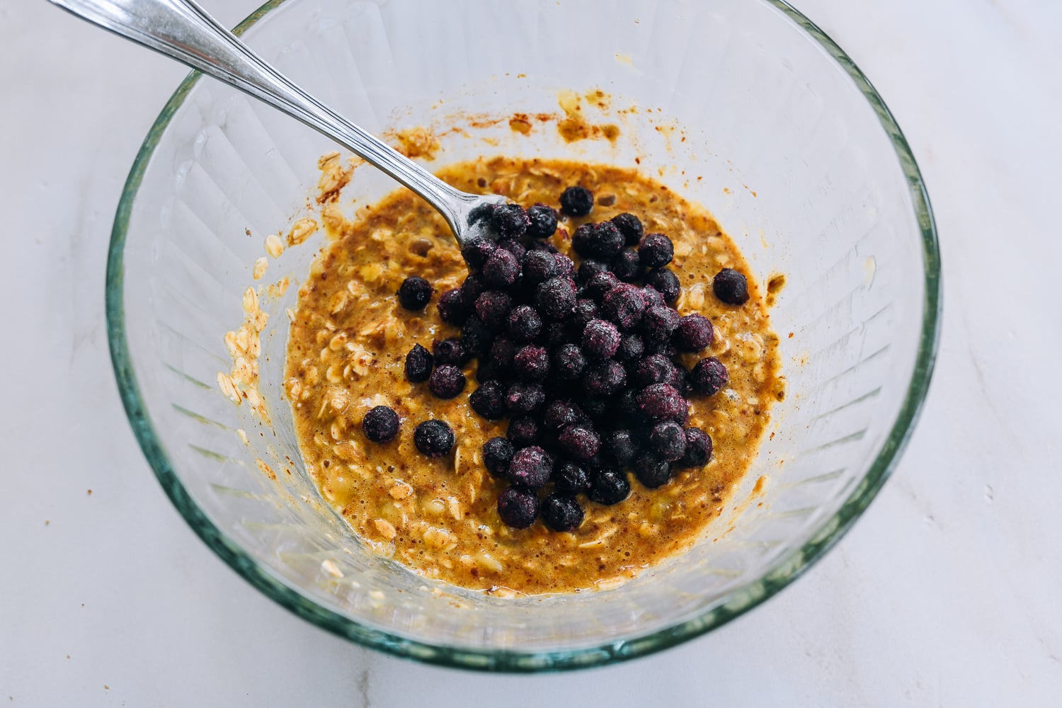 adding blueberries to banana oat pancake batter