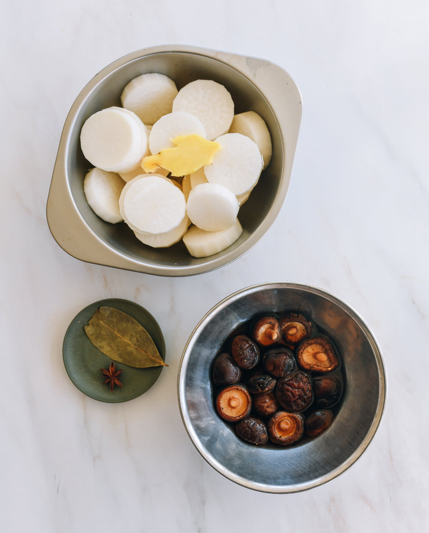 soaked mushrooms, sliced daikon, and aromatics on counter