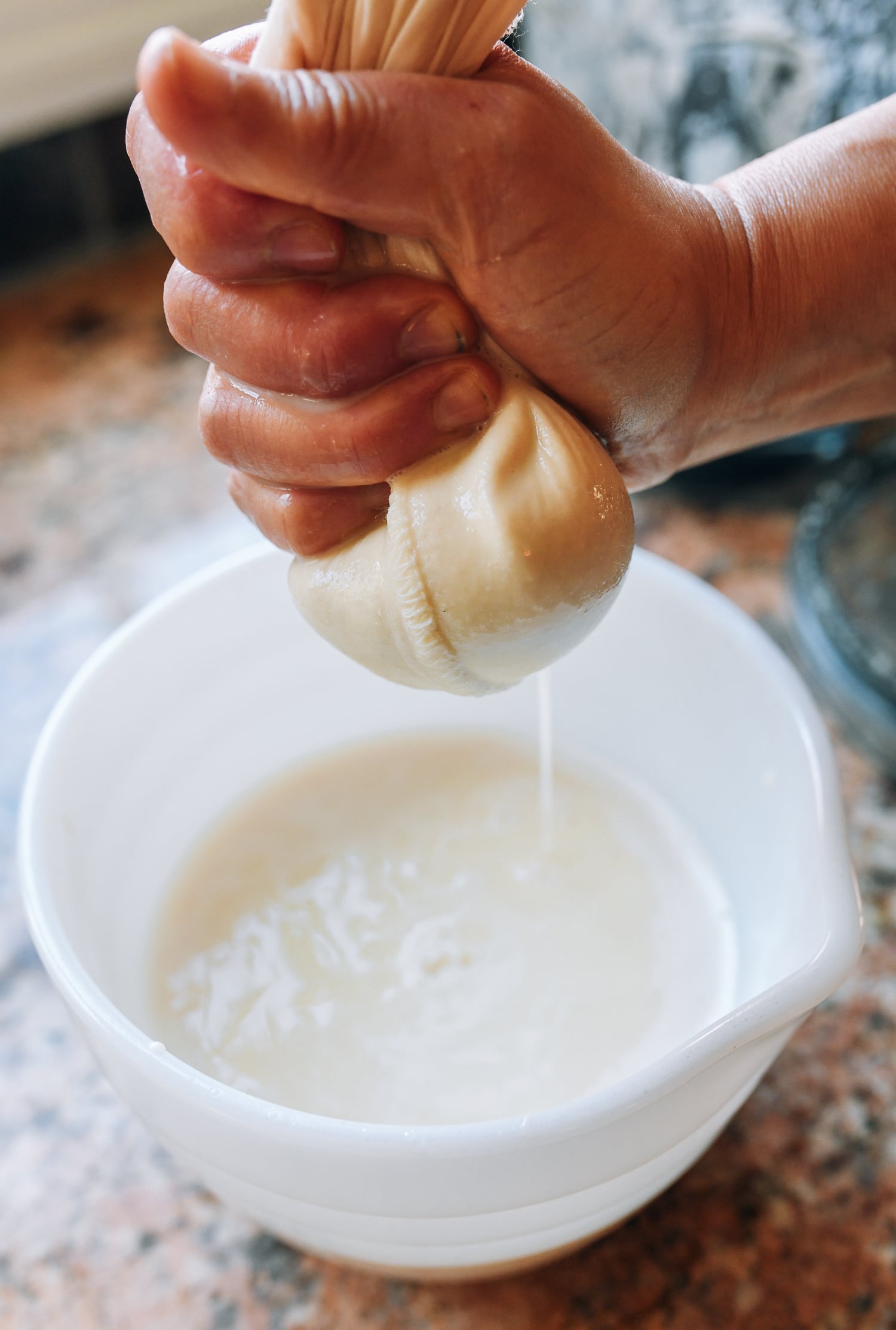 squeezing chickpea liquid in cheesecloth