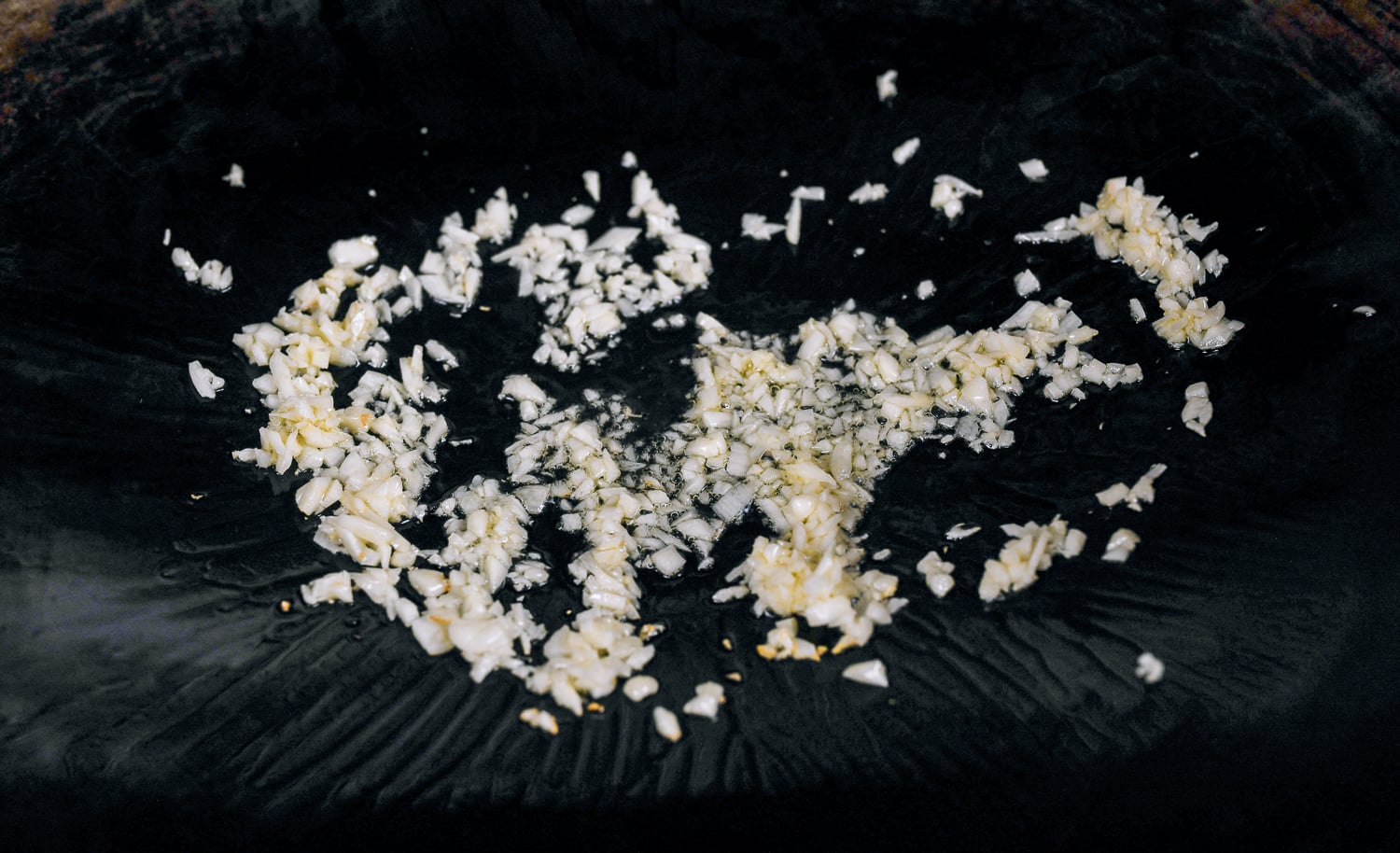 minced garlic in oiled wok