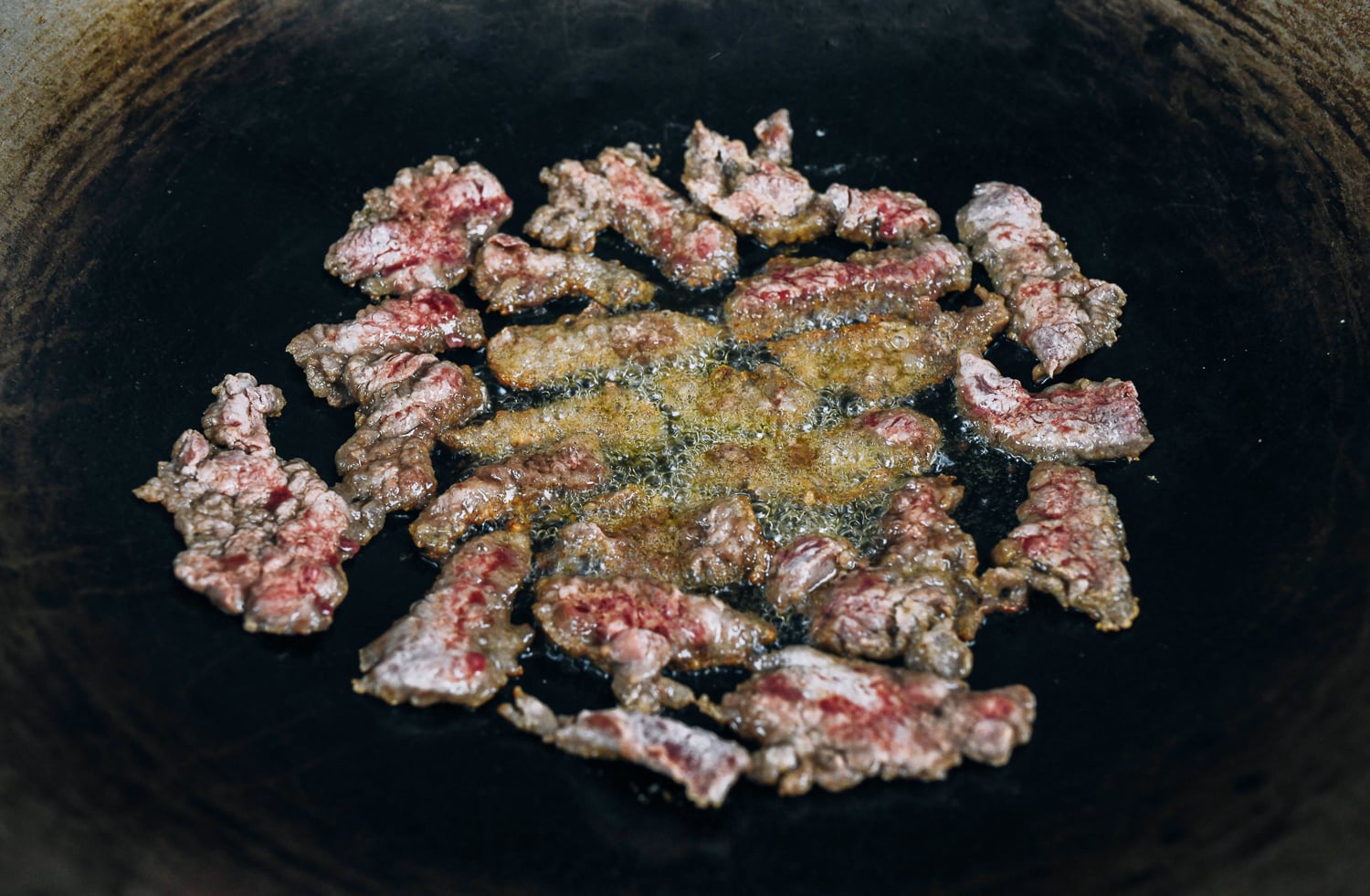 dredged beef slices in oil in wok