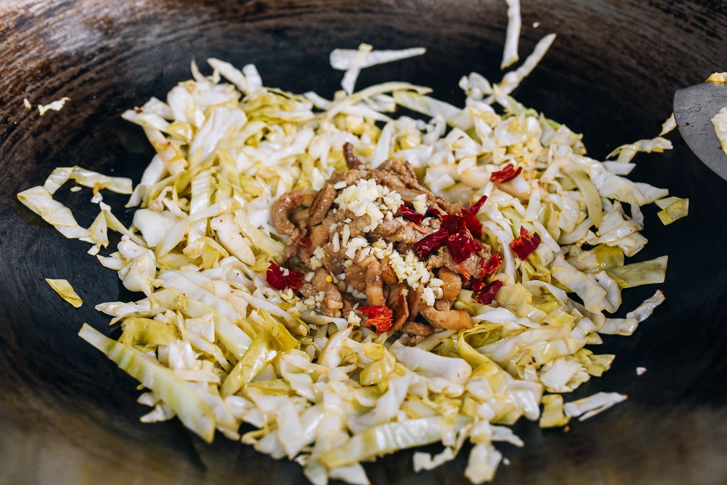 pork, garlic, chilies, and cabbage in wok