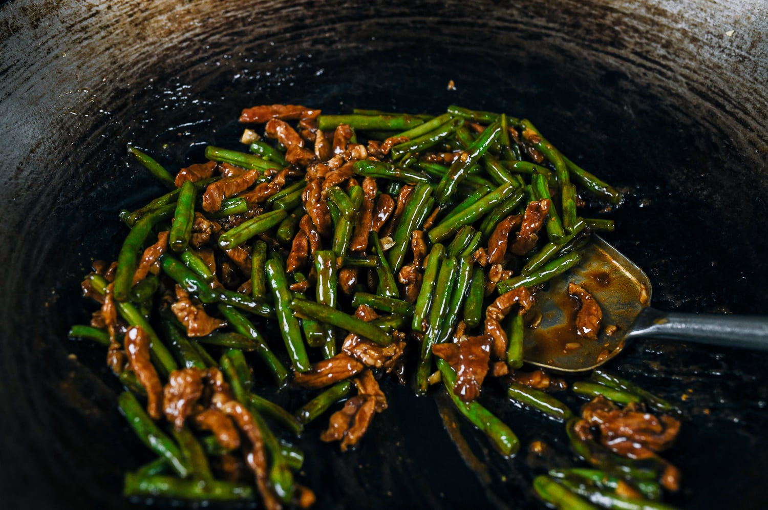 pork with green beans stir-fried together in wok