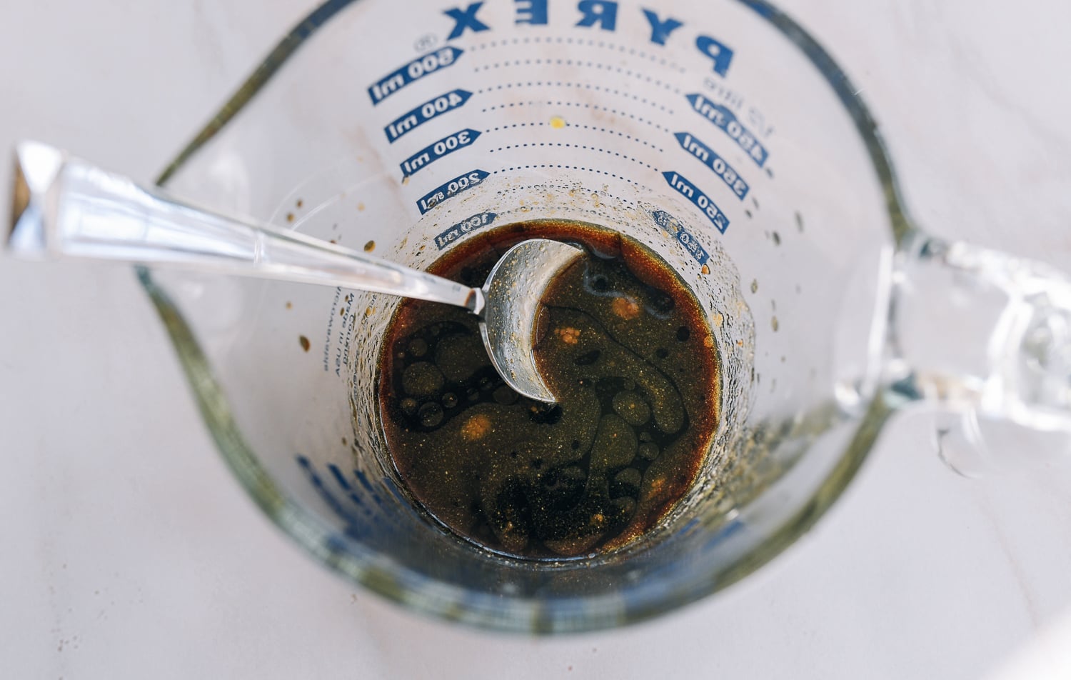sauce mixture for stir-fry in measuring cup with spoon