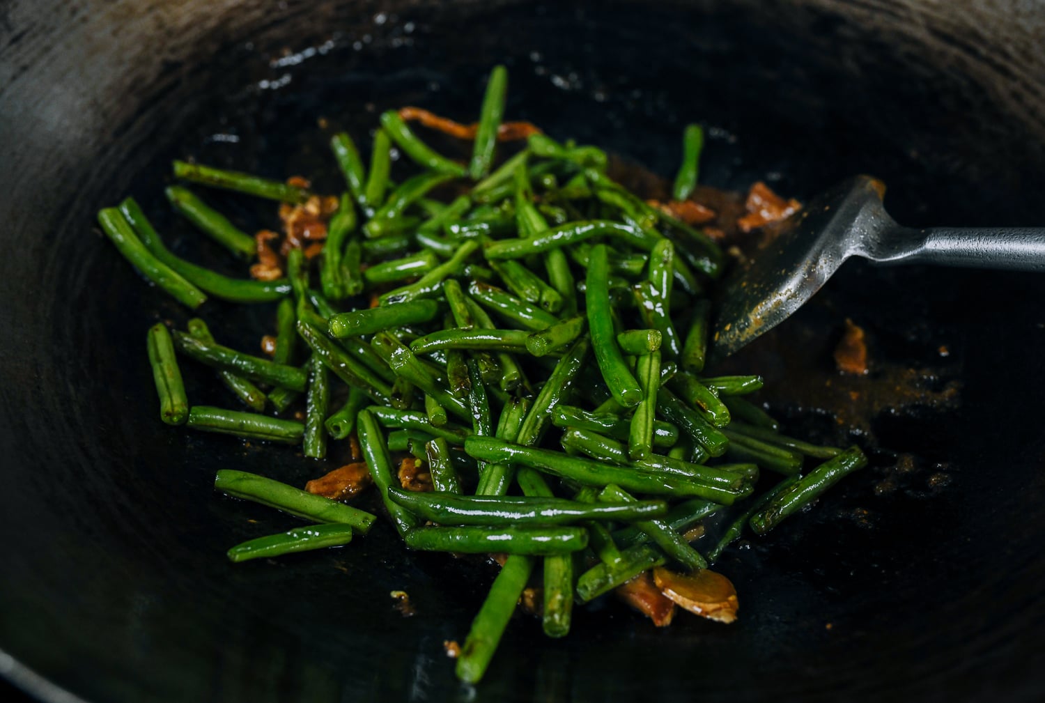 string beans added to wok with pork