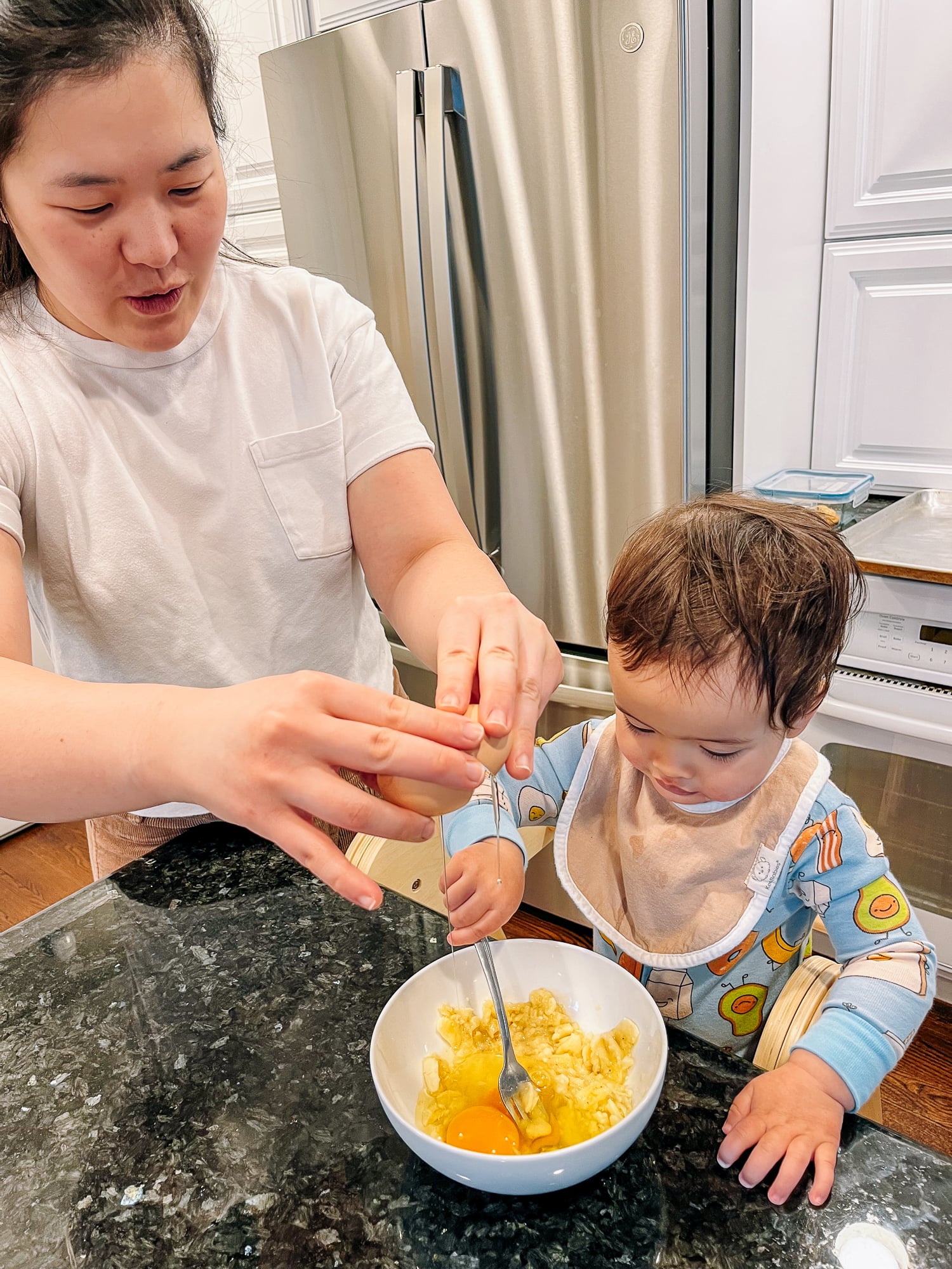 Sarah making banana pancake batter with her son