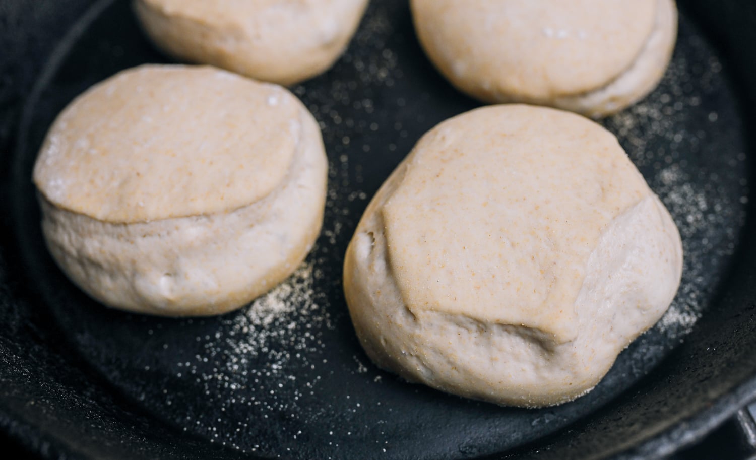 english muffins cooking in cast iron skillet