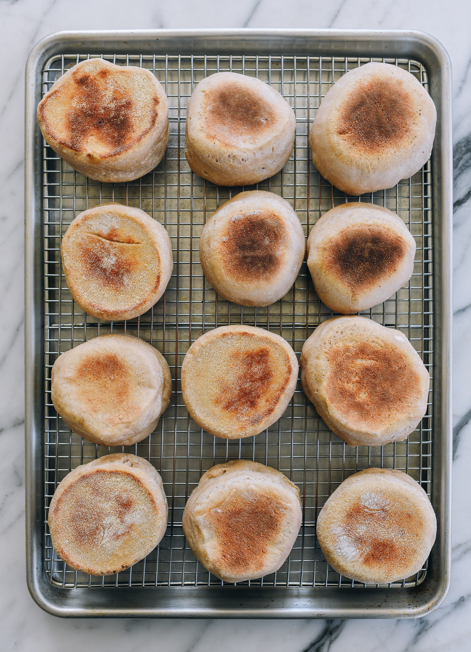 cooked english muffins on cooling rack