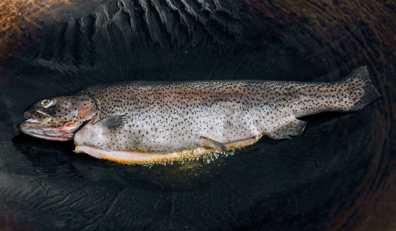 trout cooking in wok